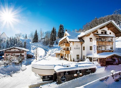 Ein malerisches Winterdorf mit schneebedeckten Häusern und schneebedeckten Bäumen. Die Sonne strahlt über die idyllische Landschaft.