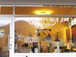 Eine Galerie mit dem Namen "Kunstwerkstatt" ist zu sehen. Der Eingang ist hell erleuchtet und zeigt bunte Kunstwerke.